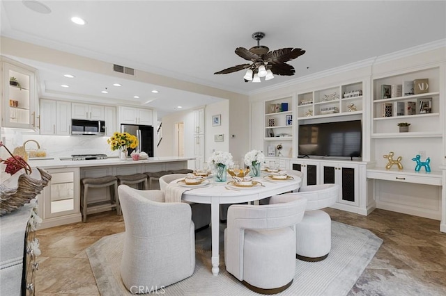 dining space featuring visible vents, crown molding, built in features, recessed lighting, and a ceiling fan