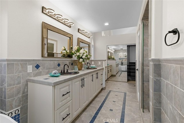 full bathroom featuring ensuite bathroom, a sink, and tile walls