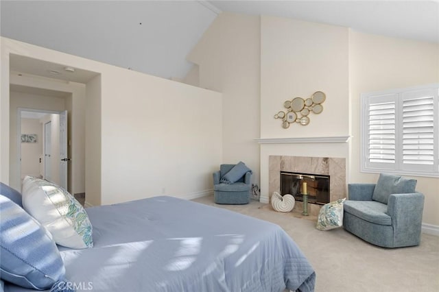 carpeted bedroom with baseboards, high vaulted ceiling, and a premium fireplace