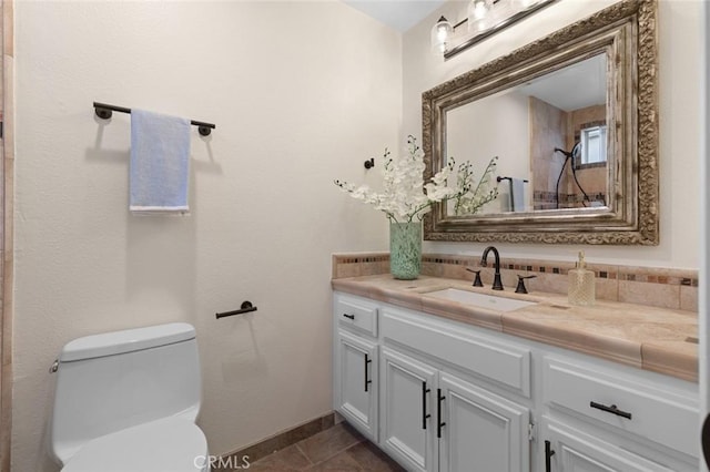 bathroom featuring vanity, tile patterned floors, toilet, and baseboards