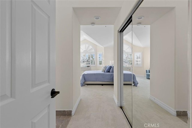 bedroom with baseboards, light colored carpet, and vaulted ceiling