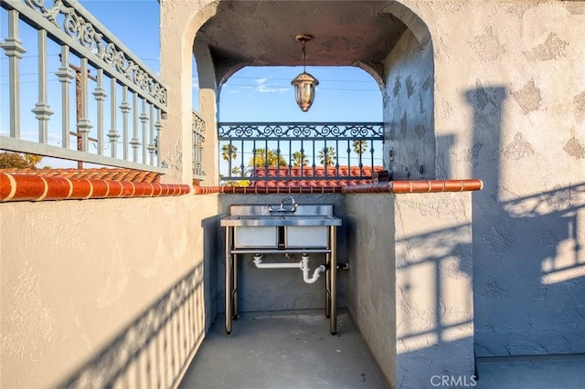 exterior space with a sink and stucco siding