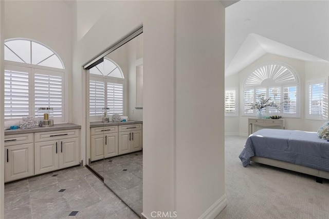 interior space featuring light carpet, baseboards, and lofted ceiling