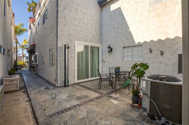 exterior space featuring stucco siding, a patio, central AC, and outdoor dining space