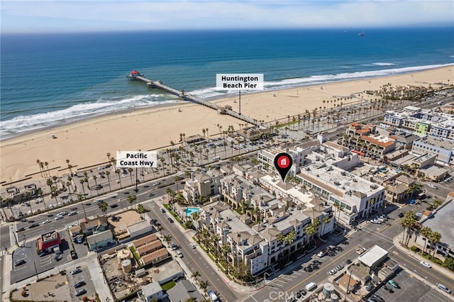 drone / aerial view featuring a water view and a beach view