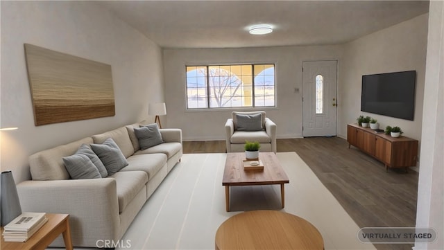 living area with baseboards and wood finished floors