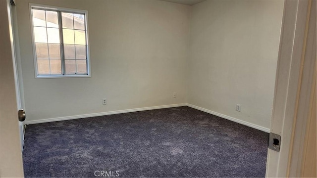 carpeted spare room featuring baseboards