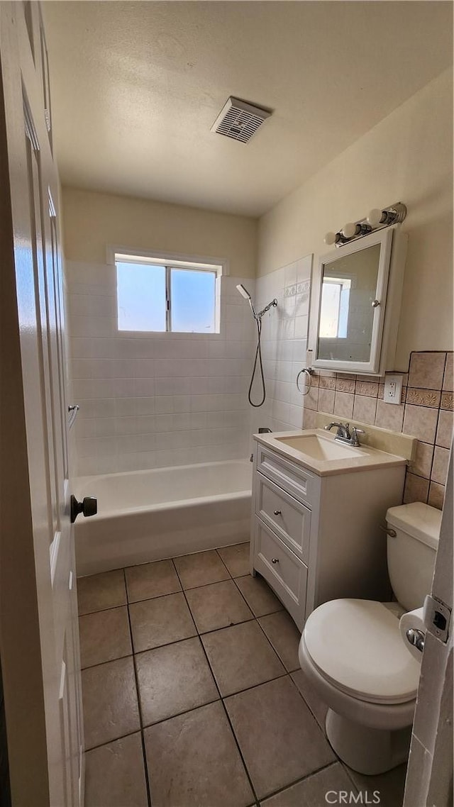 bathroom with tile walls, visible vents, toilet, shower / tub combination, and tile patterned flooring