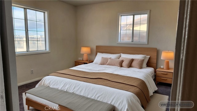 carpeted bedroom with multiple windows and baseboards