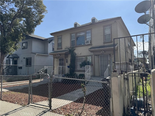 view of front facade featuring a fenced front yard, cooling unit, and a gate