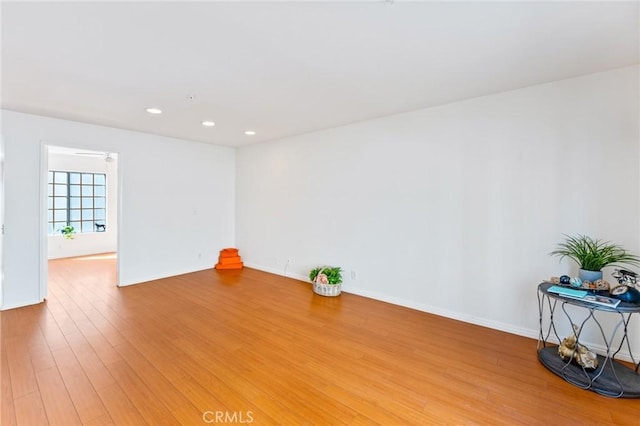 empty room featuring baseboards, light wood-style flooring, and recessed lighting