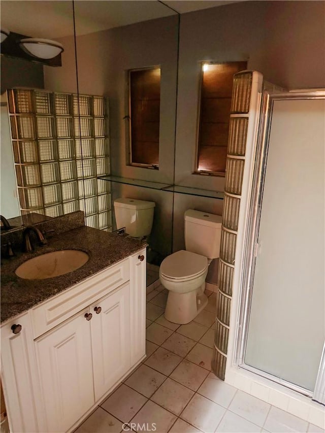 full bathroom with vanity, a shower stall, toilet, and tile patterned floors