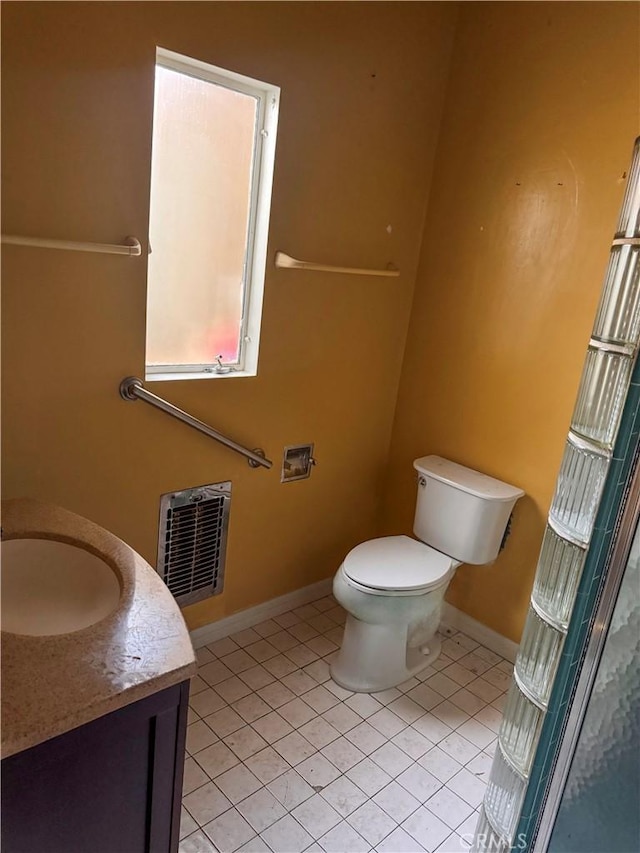 bathroom featuring toilet, visible vents, vanity, baseboards, and tile patterned floors