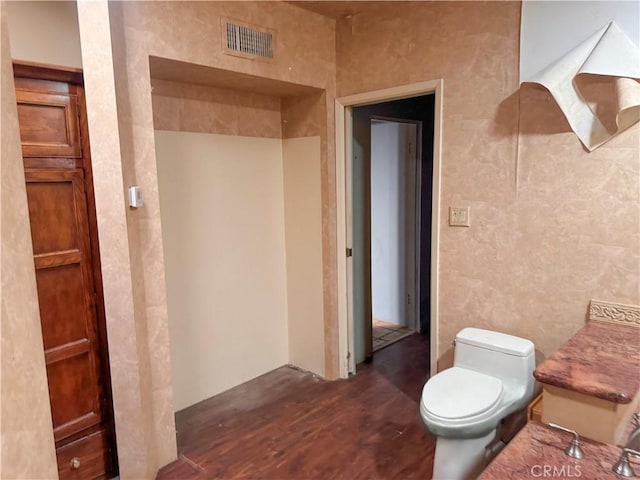 bathroom featuring toilet, visible vents, and wood finished floors