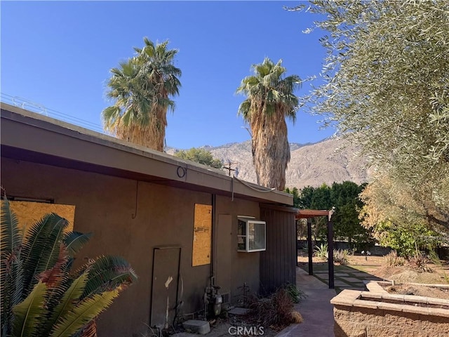 view of side of home featuring a mountain view and stucco siding