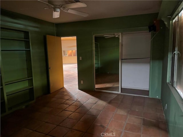 spare room with tile patterned flooring and a ceiling fan