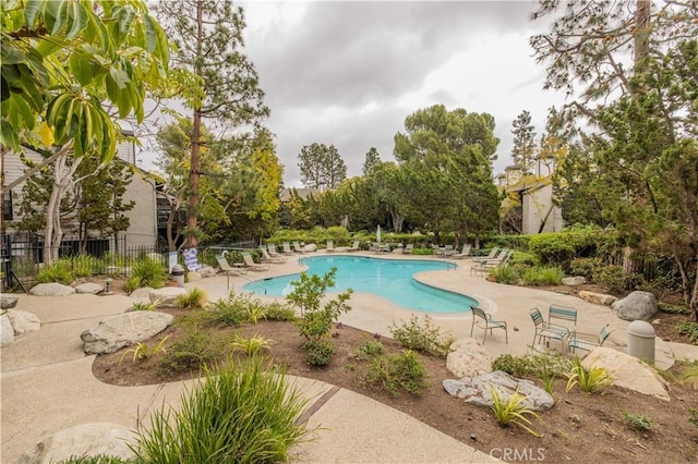 pool with a patio area and fence