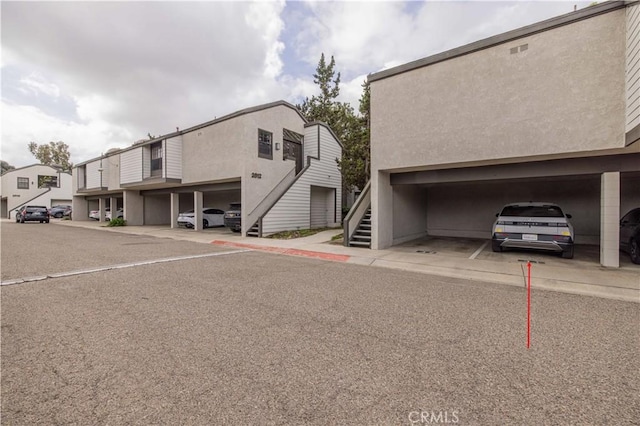 covered parking lot featuring stairway