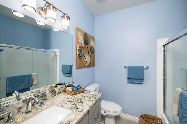 full bath featuring toilet, a shower with door, baseboards, and vanity