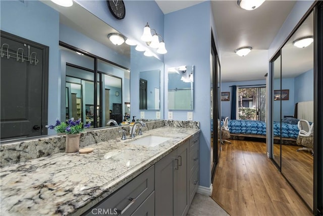 bathroom with wood finished floors, ensuite bath, and vanity