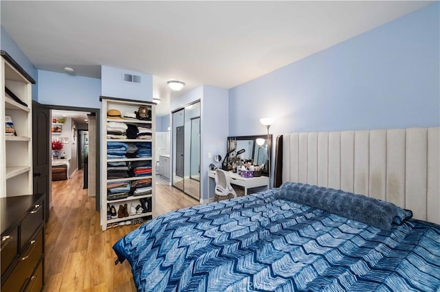 bedroom with light wood-style flooring and visible vents