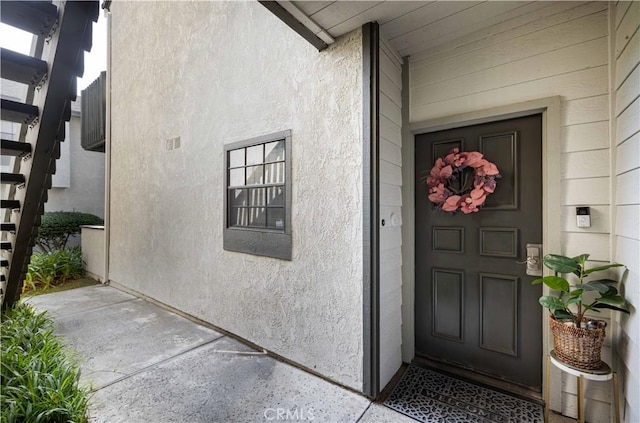 view of exterior entry featuring stucco siding