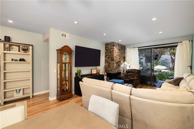 living area with baseboards, light wood-style flooring, visible vents, and recessed lighting