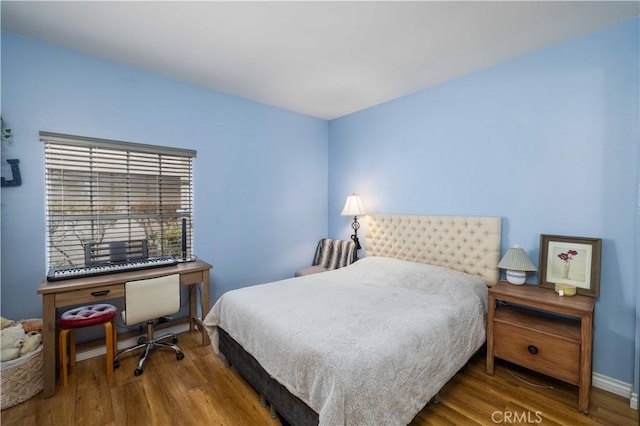 bedroom with baseboards and wood finished floors