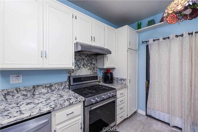 kitchen featuring appliances with stainless steel finishes, white cabinets, under cabinet range hood, and light tile patterned floors