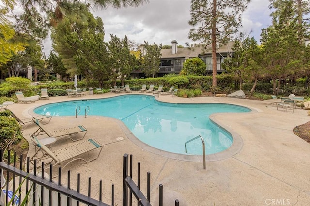 pool featuring fence and a patio