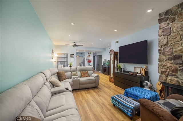 living room featuring a fireplace, recessed lighting, visible vents, ceiling fan, and light wood-type flooring