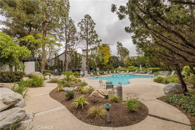 pool with a patio area and fence