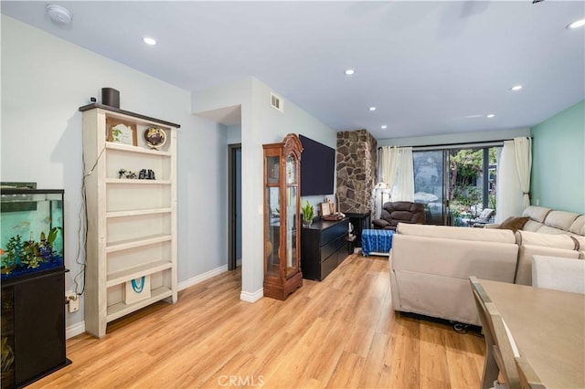 living area featuring baseboards, light wood finished floors, visible vents, and recessed lighting