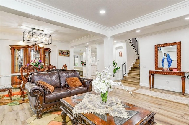 living room featuring light wood finished floors, ornamental molding, stairs, recessed lighting, and baseboards