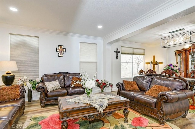 living area with wood finished floors, ornamental molding, baseboards, and recessed lighting