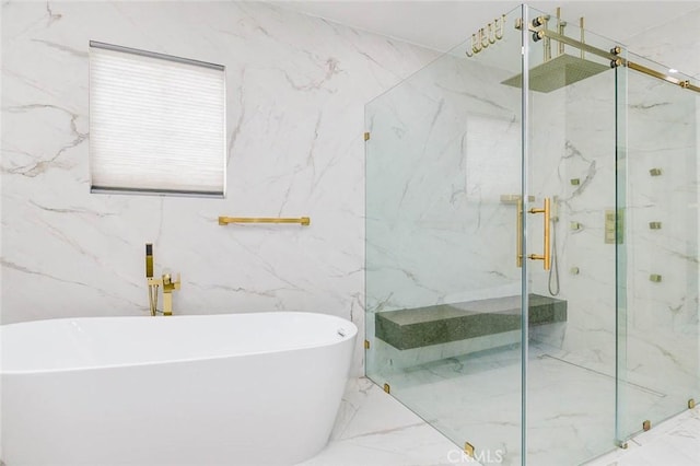full bathroom with a marble finish shower, marble finish floors, a freestanding tub, and tile walls