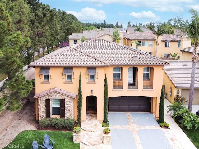 mediterranean / spanish-style house featuring concrete driveway, stucco siding, a garage, a tiled roof, and a residential view