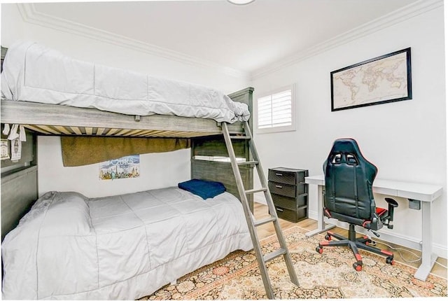 bedroom with crown molding, wood finished floors, an office area, and baseboards