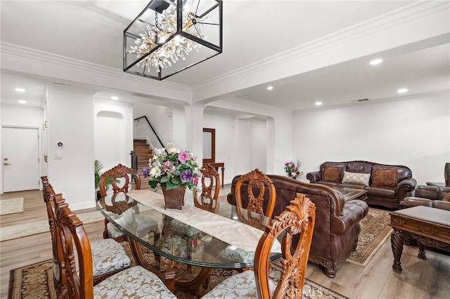 dining space featuring stairs, light wood-style floors, recessed lighting, ornamental molding, and a chandelier