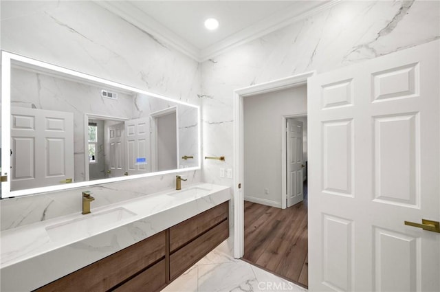 full bath featuring crown molding, marble finish floors, double vanity, and baseboards
