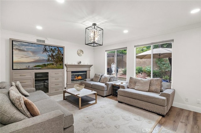 living area with light wood-style floors, beverage cooler, crown molding, recessed lighting, and baseboards