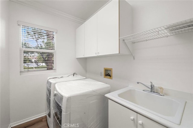 washroom with cabinet space, crown molding, baseboards, and independent washer and dryer