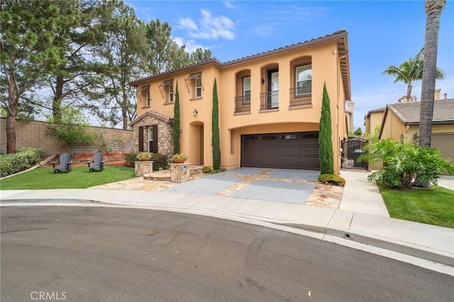 mediterranean / spanish-style house with stucco siding, a garage, driveway, fence, and a balcony