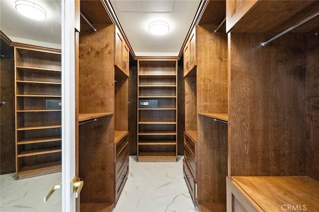 walk in closet with light marble finish floors