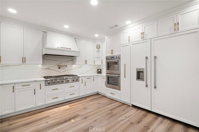 kitchen featuring premium range hood, stainless steel appliances, white cabinets, recessed lighting, and light wood-type flooring