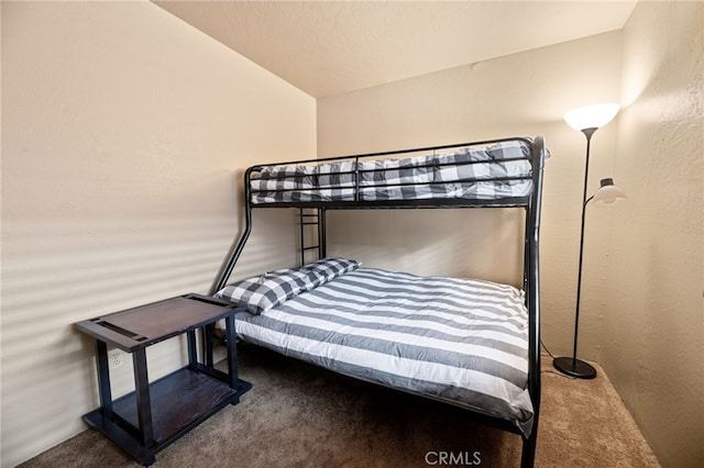 bedroom with carpet flooring and a textured wall