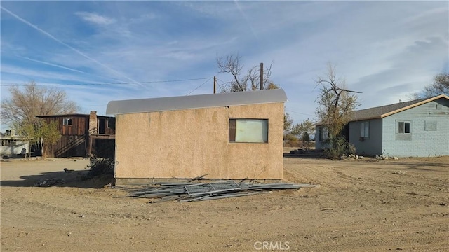 rear view of house featuring stucco siding