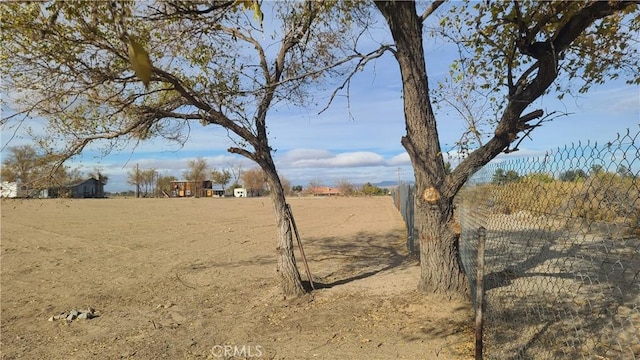 view of yard featuring fence and a rural view