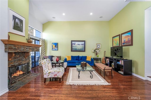 living room with high vaulted ceiling, a fireplace, baseboards, and wood finished floors