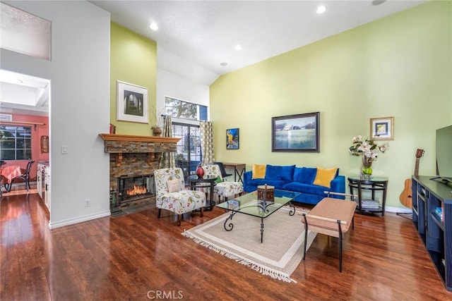 living area featuring high vaulted ceiling, recessed lighting, a fireplace, wood finished floors, and baseboards